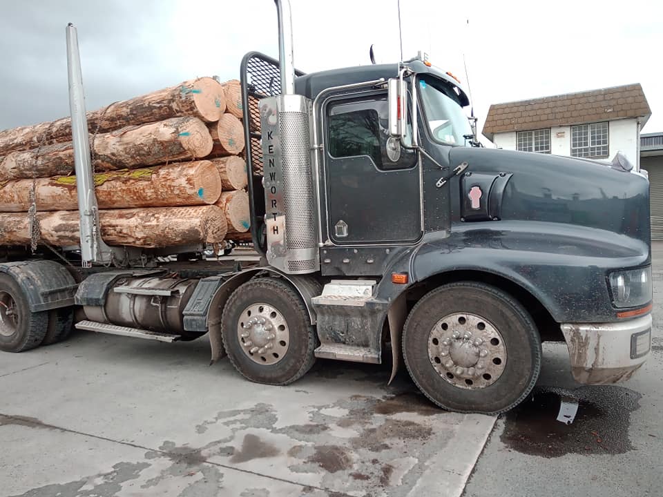 Photo of logging truck that is dusty and covered in grime